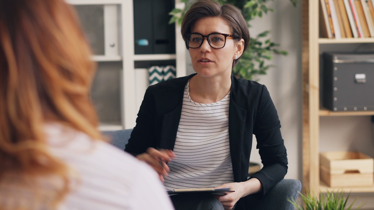 A practitioner listening to a parent during a calm office consultation.
